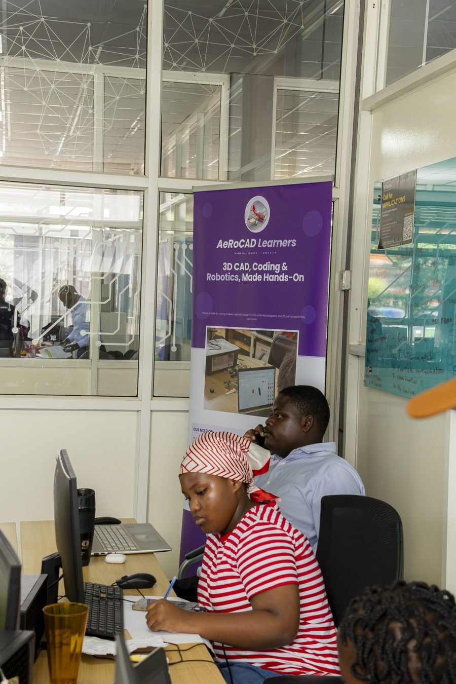 A learner working at a computer beside the AeRoCAD banner